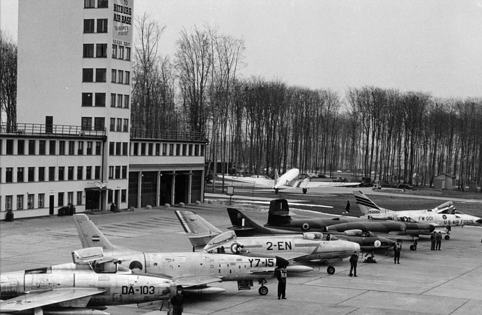 Belgijski CF-100 Canuck w towarzystwie myśliwców z innych państw NATO-wskich w zachodnioniemieckiej bazie lotniczej Bitburg (land Nadrenia-Palatynat) w 1959 roku. Na zdjęciu kolejno: F-84F Thunderstreak z Luftwaffe, holenderski F-86K Sabre, francuski Dassault Mystère IVA, brytyjski Hawker Hunter, CF-100 i amerykański F-100C Super Sabre. W tle C-47 Skytrain; fot. Gary Schulz, USAF