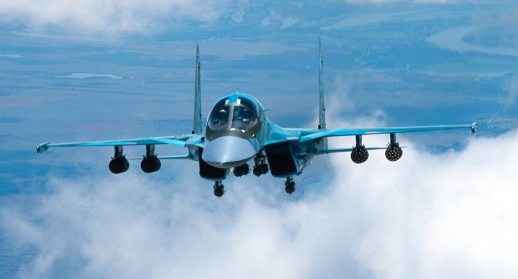 Su-34 w locie. Pod skrzydłami widoczne wieloprowadnicowe wyrzutnie niekierowanych pocisków rakietowych (fot. PAO Kompanija Suchoj)