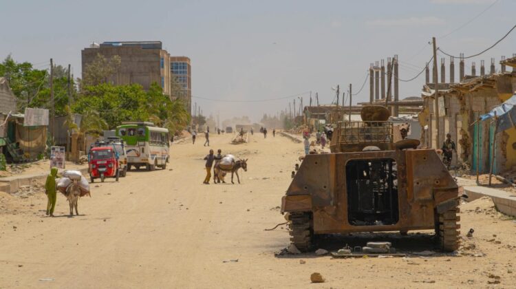 widok na ulicę w mieście Hawzen w Tigraju, po prawej stronie zniszczony transporter opancerzony typu 89
