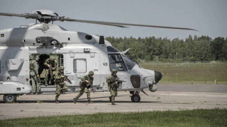 szwedzki NH90 widziany z profilu, ze śmigłowca wysiada desant
